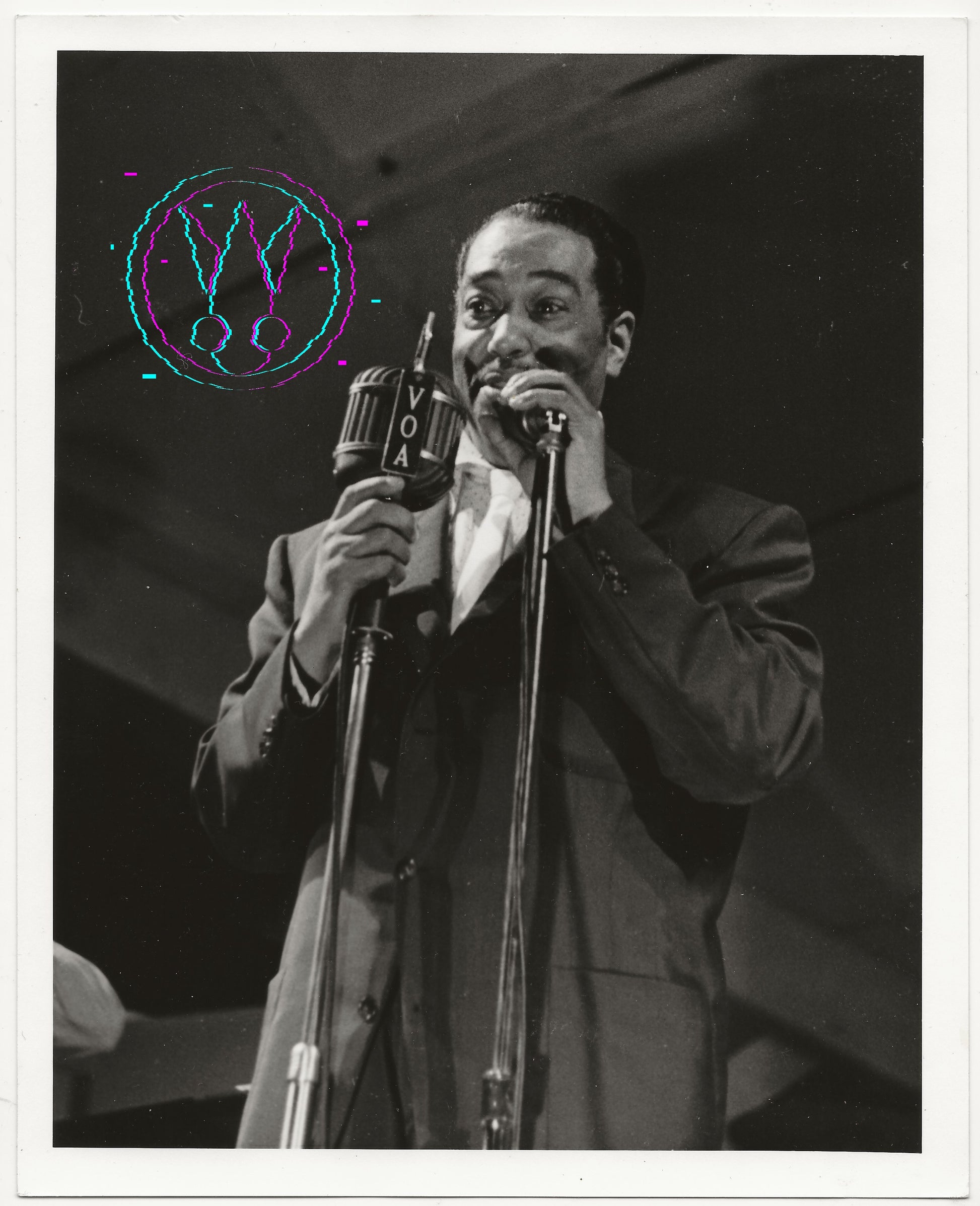 Black and white vintage photograph of a man singing into a microphone on stage, wearing a suit jacket and shirt. The photo has a white border and a colorful circular graphic overlay on the upper left.