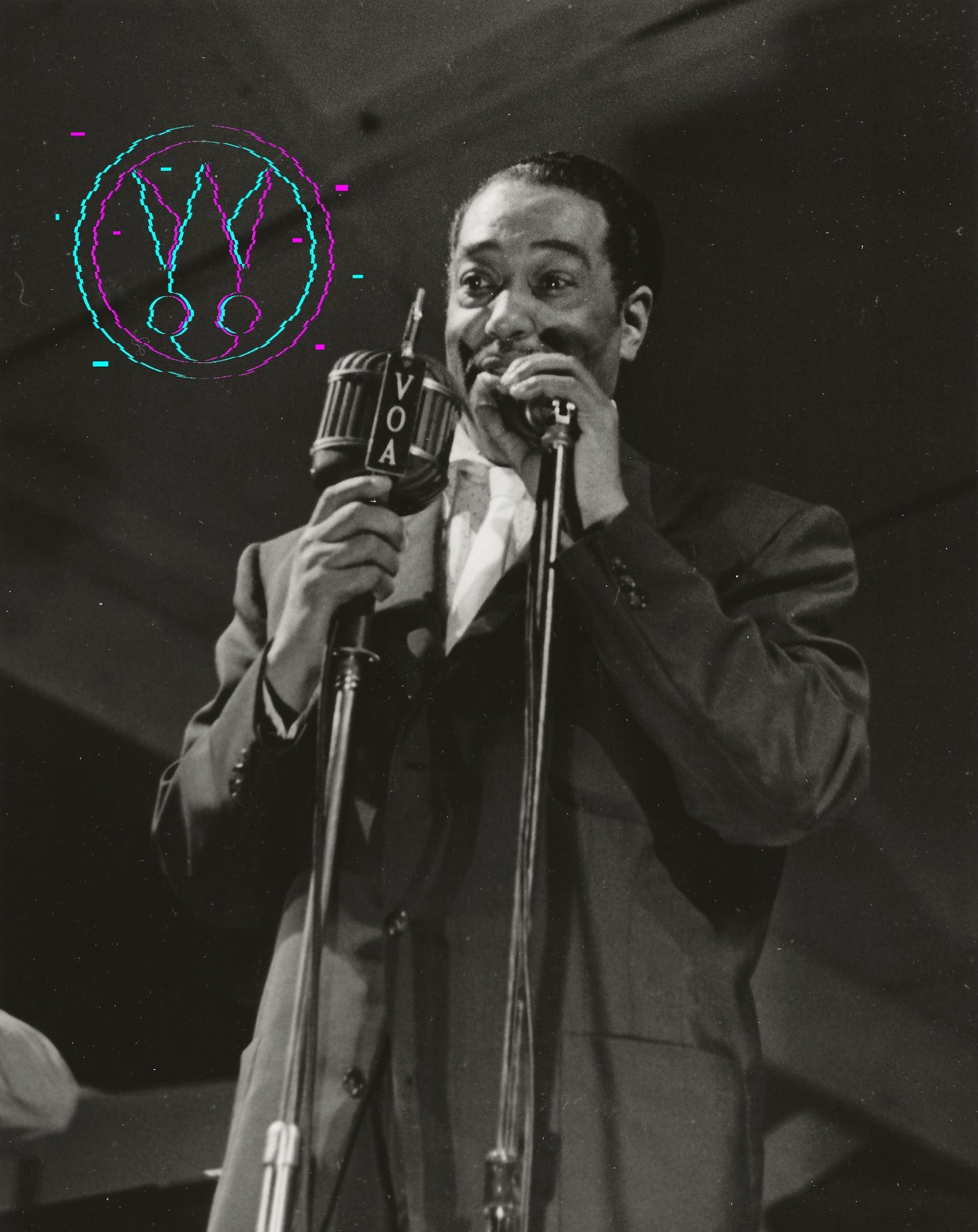 Black and white photograph of a man singing into a vintage microphone on stage, wearing a suit and tie. A colorful abstract graphic overlay is visible in the upper left corner.
